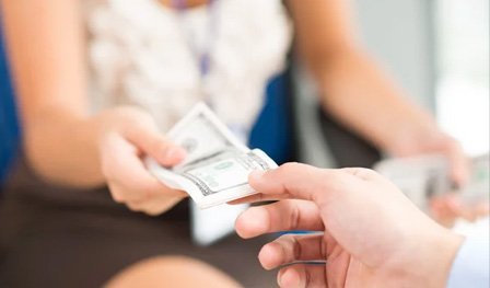 Woman handing money to man.